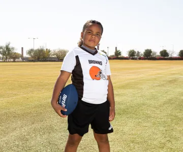 Girl wearing NFL Browns jersey playing Flag Football