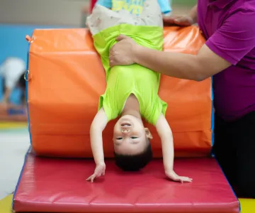 Little toddler boy working out at the indoor gym excercise
