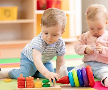 Nursery babies playing with educational toys in creche, early learning