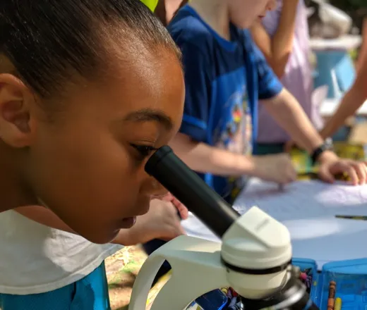 Girling looking into a microscope at some slides