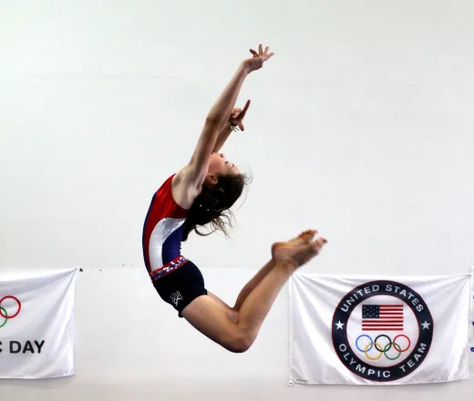 Girl gymnast in the air striking a pose